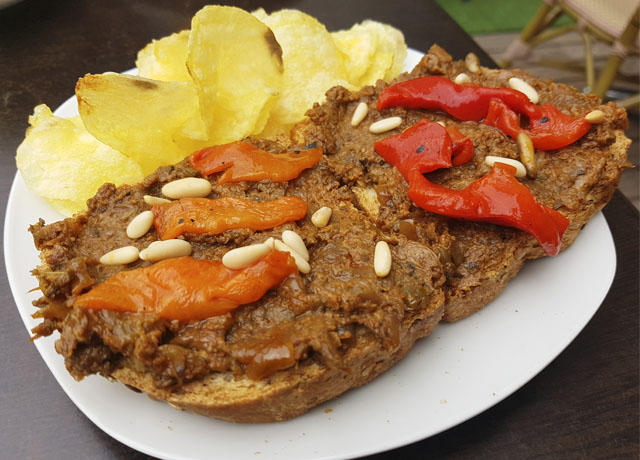 Tostada de morcilla vegetal con pimientos rojos asados y piñones